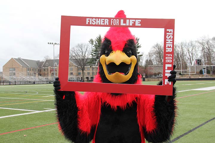 Cardinal Mascot holding a sign with text 