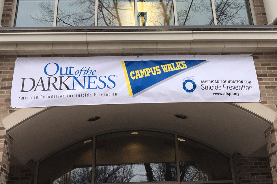 A banner promoting the Out of Darkness walk hangs on the Wegmans School of Nursing.